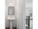 Stylish powder room with a pedestal sink, modern lighting, and neutral decor, conveniently located near the living area at 244 Church St, Lawrenceville, GA 30046