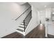 Hallway with a modern staircase featuring black railings and beautiful gray hardwood floors at 244 Church St, Lawrenceville, GA 30046