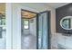 Bathroom featuring modern vanity, cabinets, round mirror and door to outdoor living area at 2740 Drew Valley Ne Rd, Brookhaven, GA 30319