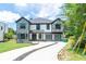 Exterior facade of a large 2 story home with stone and white wood accents and a three car garage at 2740 Drew Valley Ne Rd, Brookhaven, GA 30319