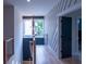 Hallway with modern accent wall, wooden floors, and a dark door at 2740 Drew Valley Ne Rd, Brookhaven, GA 30319