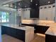 Elegant kitchen featuring white cabinets, a dark island, marble countertops, and stainless steel appliances at 2740 Drew Valley Ne Rd, Brookhaven, GA 30319