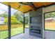 Covered outdoor living space featuring a fireplace, fan, and view of the fenced backyard at 2740 Drew Valley Ne Rd, Brookhaven, GA 30319