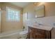 Traditional bathroom featuring a vanity with dark wood cabinet, tiled walls, and window at 3710 A B Lynn Dr, Powder Springs, GA 30127