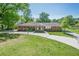 Ranch-style brick home boasts a spacious front yard and charming curb appeal with a long driveway on a sunny day at 3710 A B Lynn Dr, Powder Springs, GA 30127