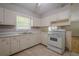 Bright kitchen with white cabinets, matching appliances, and views to the back yard at 3710 A B Lynn Dr, Powder Springs, GA 30127