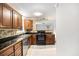 Cozy kitchen features wood cabinets, black countertops, stainless steel appliances, and a stylish backsplash at 7248 Banks Mill Rd, Douglasville, GA 30135