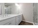 Bathroom featuring dual sinks, a large mirror, bright lighting, and a walk-in shower at 18 Black Gum Ln # 53, Auburn, GA 30011