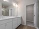 Bathroom featuring dual sinks, a large mirror, bright lighting, walk-in closet, and a walk-in shower at 18 Black Gum Ln # 53, Auburn, GA 30011