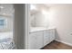 Bathroom featuring dual sinks, a large mirror, bright lighting, and open view to a bedroom at 18 Black Gum Ln # 53, Auburn, GA 30011