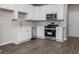 Well-designed kitchen with white cabinets, stainless steel appliances and a modern backsplash at 18 Black Gum Ln # 53, Auburn, GA 30011