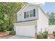 Side view of the home with a 2 car garage, lovely landscaping, and neutral vinyl siding at 606 Windcroft Nw Cir, Acworth, GA 30101