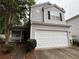 Charming two-story home with a large white garage door, well-kept landscaping, and mature trees at 606 Windcroft Nw Cir, Acworth, GA 30101