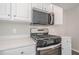 Close-up of oven range and microwave in a kitchen with white cabinets and countertops at 606 Windcroft Nw Cir, Acworth, GA 30101
