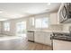 Bright kitchen featuring white cabinets, stainless steel appliances, and access to the living room at 606 Windcroft Nw Cir, Acworth, GA 30101