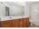 Bathroom features a double vanity, large mirror, and tub shower at 7454 Silver Arrow Se Trl, Austell, GA 30168