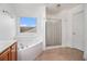 Bright bathroom with a shower, tub, and tile flooring at 7454 Silver Arrow Se Trl, Austell, GA 30168