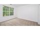 Bedroom featuring neutral carpet, natural light, and white trim at 7454 Silver Arrow Se Trl, Austell, GA 30168