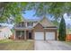 Traditional two-story home boasting a brick facade, shuttered windows, and a two-car garage at 7454 Silver Arrow Se Trl, Austell, GA 30168