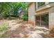 Exterior of home featuring a small patio area and a lush green space at 12080 Mountain Laurel Dr, Roswell, GA 30075