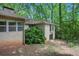 Exterior of home with partial basement entrance and mature trees at 12080 Mountain Laurel Dr, Roswell, GA 30075