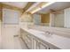 Bathroom with a double sink vanity, patterned wallpaper, and tiled floors at 12080 Mountain Laurel Dr, Roswell, GA 30075