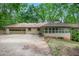 Rear exterior view of home with garage, sunroom, and well-maintained lawn at 12080 Mountain Laurel Dr, Roswell, GA 30075