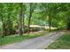 Charming single-story home with lush landscaping and a long driveway, nestled among mature trees at 12080 Mountain Laurel Dr, Roswell, GA 30075