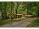 Charming single-story home with lush landscaping and a long driveway, nestled among mature trees at 12080 Mountain Laurel Dr, Roswell, GA 30075