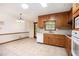 Eat-in kitchen featuring tile flooring, wood cabinets, and white appliances at 12080 Mountain Laurel Dr, Roswell, GA 30075
