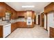 Spacious kitchen featuring tile flooring, wood cabinets, and white appliances at 12080 Mountain Laurel Dr, Roswell, GA 30075