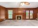 Living room featuring wood paneled walls, brick fireplace, and French doors at 12080 Mountain Laurel Dr, Roswell, GA 30075