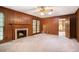 Living room with paneled walls, brick fireplace, and doorway to kitchen at 12080 Mountain Laurel Dr, Roswell, GA 30075