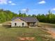 Lovely single-story home with a covered porch, mature trees, and a spacious front yard under a sunny sky at 130 Williams Rd, Villa Rica, GA 30180