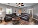 Open-concept living room with a dark leather sofa, wood-look flooring, and neutral walls at 130 Williams Rd, Villa Rica, GA 30180
