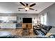 Comfortable living room with dark leather sofa, wood-look floors, a ceiling fan, and a view into the kitchen at 130 Williams Rd, Villa Rica, GA 30180