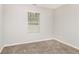 Bedroom features neutral walls and carpet, and a window at 155 Oak Terrace Dr, Covington, GA 30016