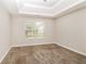 Bedroom featuring neutral walls, carpeted flooring, a large window, and a tray ceiling at 155 Oak Terrace Dr, Covington, GA 30016