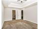 Bedroom featuring neutral walls, carpeted flooring, tray ceiling, and access to bathroom and closet at 155 Oak Terrace Dr, Covington, GA 30016