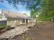 Spacious backyard featuring a stone patio, a pergola, and mature trees providing shade at 2012 Elm Grove Ln, Hampton, GA 30228