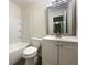 Bright bathroom featuring a tub-shower combination with a white tiled surround and storage cabinet at 2012 Elm Grove Ln, Hampton, GA 30228