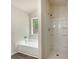 Clean bathroom with white tiles, a shower, tub, and a window providing natural light at 2012 Elm Grove Ln, Hampton, GA 30228