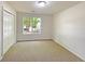 Unfurnished bedroom featuring a double door closet, a window, and carpeted floors at 2012 Elm Grove Ln, Hampton, GA 30228