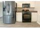 Modern kitchen with stainless steel appliances, white cabinetry, and a black gas range oven at 2012 Elm Grove Ln, Hampton, GA 30228