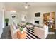 Bright, staged living room featuring a fireplace, ceiling fan, stylish furnishings, and hardwood floors at 2012 Elm Grove Ln, Hampton, GA 30228