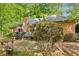 Backyard view of brick home with chimney and deck surrounded by mature trees offering shade at 318 Dogwood Trce, Mcdonough, GA 30252