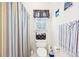 Standard bathroom featuring a toilet, patterned shower curtain, and matching striped towel at 318 Dogwood Trce, Mcdonough, GA 30252