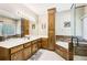 Bathroom showcasing a corner soaking tub with wood accents, dual sinks, and a glass-enclosed shower at 318 Dogwood Trce, Mcdonough, GA 30252