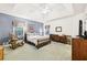 Large bedroom with tray ceilings, rocking chair, and blue accent wall at 318 Dogwood Trce, Mcdonough, GA 30252
