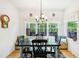 Bright dining area with large windows overlooking a wooded area, featuring a blue table at 318 Dogwood Trce, Mcdonough, GA 30252